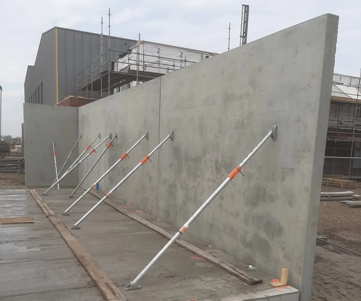 Prefab betonwand met schoren op de bouwplaats